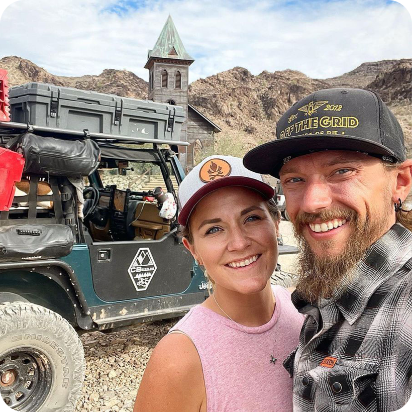 Couple standing in front of their Jeep