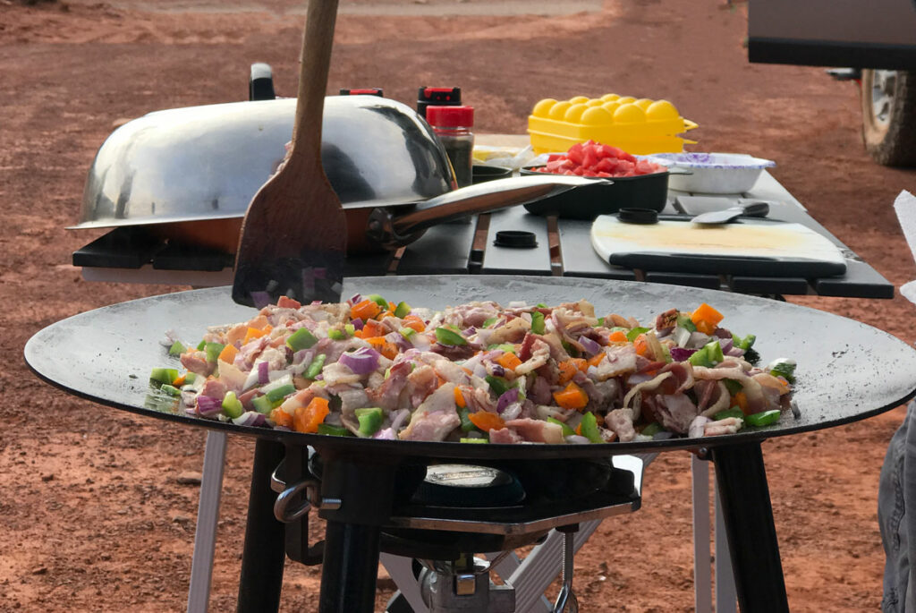 Camp Kitchen set up with a skottle making a stir fry in the desert